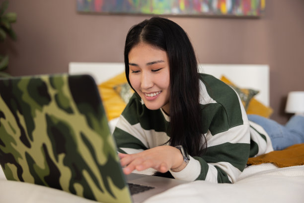 高兴地笑着，有漂亮的白牙齿，亚洲哈萨克斯坦年轻女孩，女士，女士，上网购物，网上购物，愉快地购买新衣服，物品，家居用品图片下载