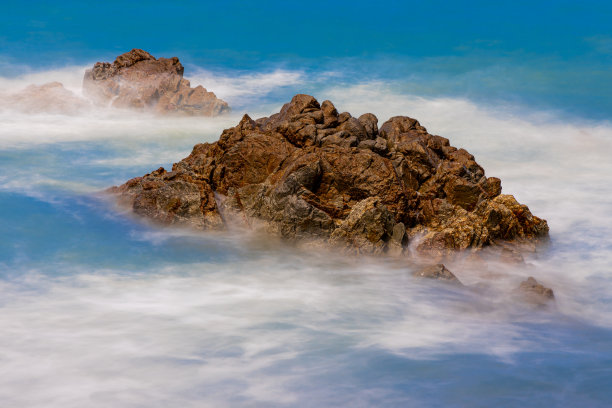长时间暴露在泰国普吉岛芭东海滩上海浪撞击岩石的照片图片下载