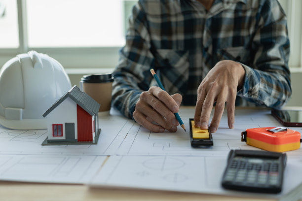 建筑师室内设计师与房屋设计家装文件Persson工程师-手绘计划与建筑设备打印。建筑师们在桌边聊天图片下载