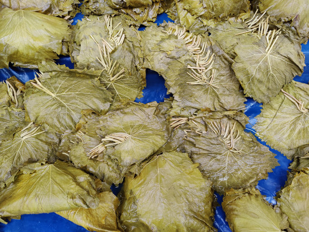 在市场摊位上为填馅的葡萄叶准备的叶子图片下载