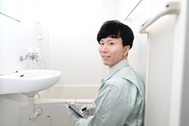 穿着工作服的亚洲人正在检查浴室图片下载