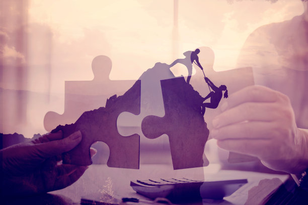 男人在帮助他的朋友爬山图片下载