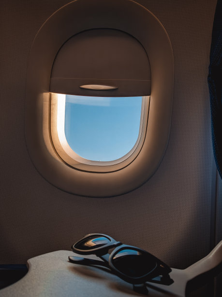 太阳镜与飞机窗口背景图片下载
