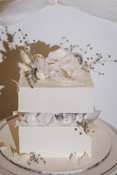 细节时髦的蛋糕与数字新生儿，翅膀天使和银色装饰。庆祝洗礼的概念。宝宝生日派对上的美味招待。特写镜头。侧视图。蛋糕上的背景白色照片区。图片下载