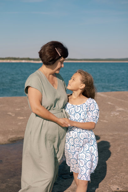 奶奶和她的小孙女在阳光明媚的夏天在海边度过周末和散步的照片。图片下载
