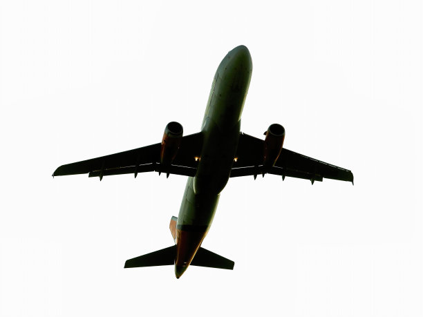 白色背景上正在飞行的飞机。真正的飞机在天空从下往上看。图片下载