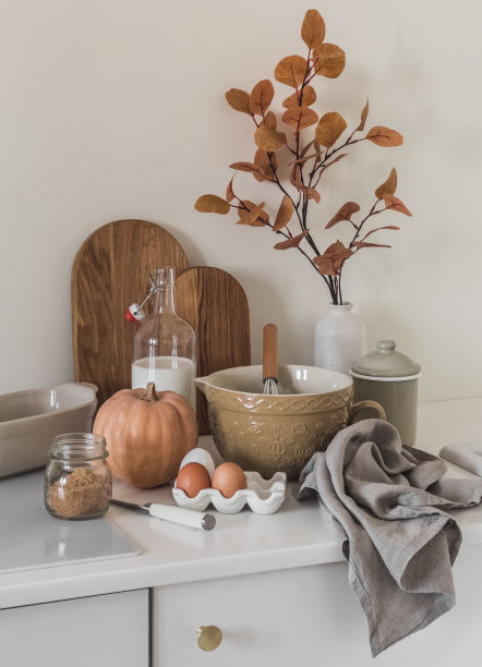 舒适的秋季厨房内部-烹饪南瓜糕点。厨房桌子上的食材和菜肴图片下载