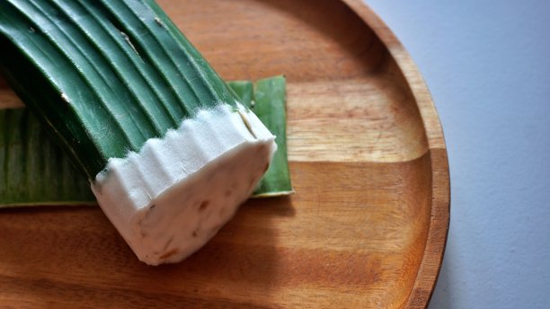 近距离复制空间，平铺由发酵大豆制成的方形生豆豉，用香蕉叶包裹。陈列在传统市场或购物中心的食品杂货图片下载
