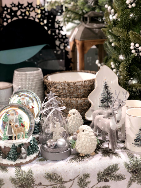 商店橱窗里的圣诞装饰品有白色、绿色和灰色，有驯鹿、小鸟、餐具和雪球图片下载