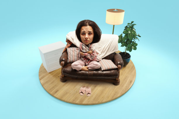 生病的女人，头大身体小，坐在家里盖着毯子的沙发上，在房间里孤立的蓝色背景。3 d渲染岛。图片下载