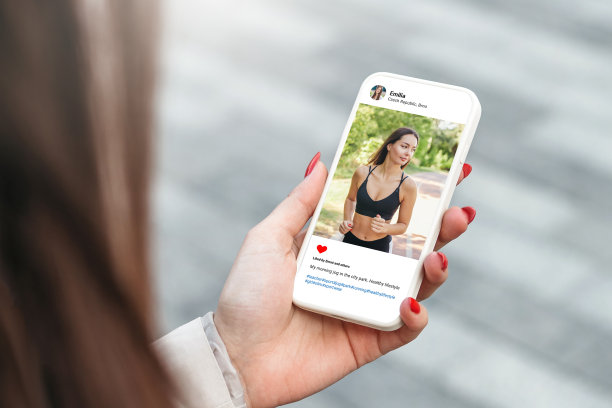 一个女人在公园里用手机看着漂亮模特的照片图片下载