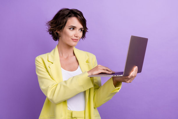 照片自信的业务项目经理年轻女管理员抱着上网本程序开发人员孤立在紫色的背景图片下载