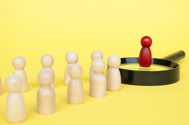 领导概念，红色人物站在放大镜上领导其他人物在黄色封面背景上图片下载