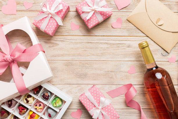 情人节装饰购物的俯视图照片，包，酒，瓶子，信封，礼物，盒子，糖果和红色的心在彩色背景与空白的空间。帧的背景图片下载