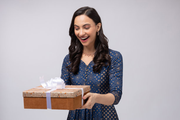 美丽的印度妇女穿着传统服装，拿着礼盒庆祝排灯节，孤立在白色背景的股票照片图片下载