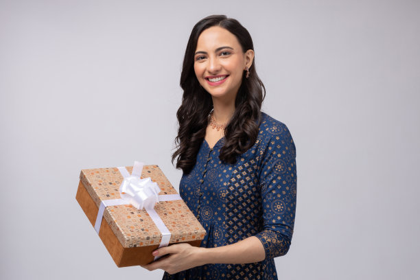 美丽的印度妇女穿着传统服装，拿着礼盒庆祝排灯节，孤立在白色背景的股票照片图片下载