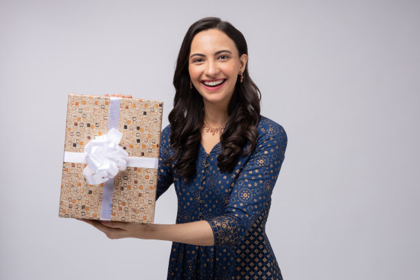 美丽的印度妇女穿着传统服装，拿着礼盒庆祝排灯节，孤立在白色背景的股票照片图片下载