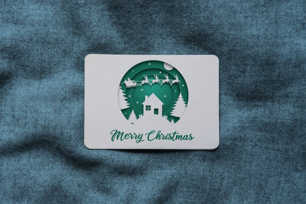 圣诞卡用绿色彩纸剪纸风格的圣诞老人、会飞的驯鹿和圣诞快乐的文字图片下载