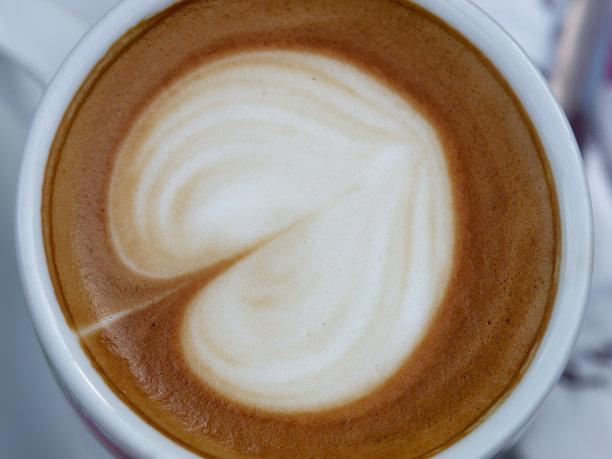 头顶上的特写照片，咖啡馆的桌子上有一个带有泡沫的心形咖啡杯图片下载