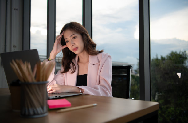 年轻的亚洲女商人晚上在办公室用笔记本电脑加班的照片图片下载