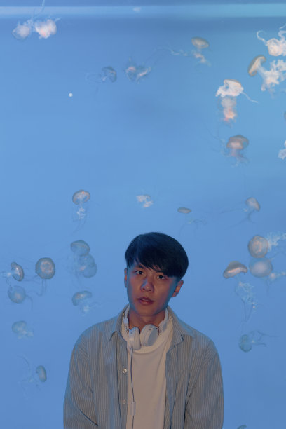 一个戴着耳机的人正在水族馆里观察海洋生物——周末活动、旅行生活、人和生物图片下载