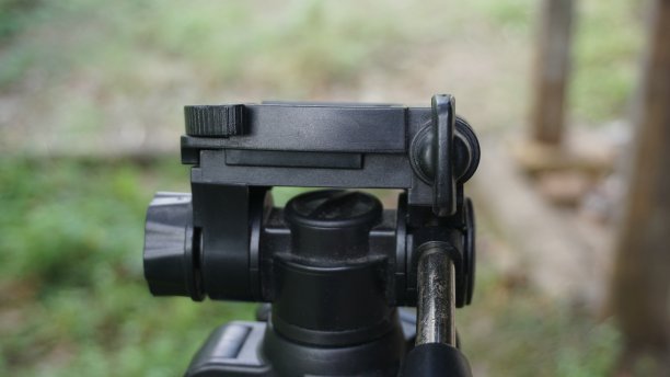 三脚架的特写，背景是模糊的绿草图片下载