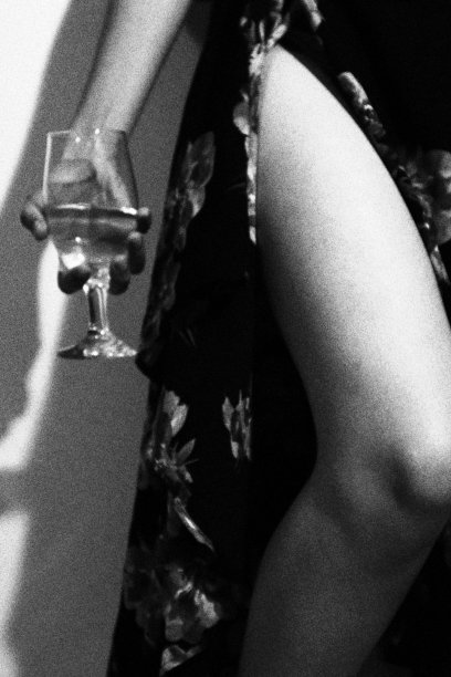 照片中的女孩穿着长长的花裙，手里拿着一杯香槟。单色黑白调图片下载