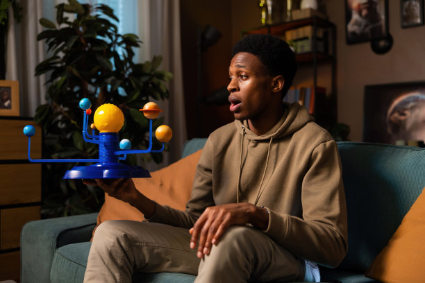 这张照片展示了宇宙的美丽，一个非洲裔美国人拿着一组行星，思考着太空的奥秘图片下载