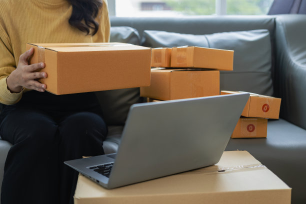 美丽的亚洲创业老板在家里用笔记本电脑和包装盒在中小企业供应链，全渠道采购或在线销售的想法。特写照片图片下载