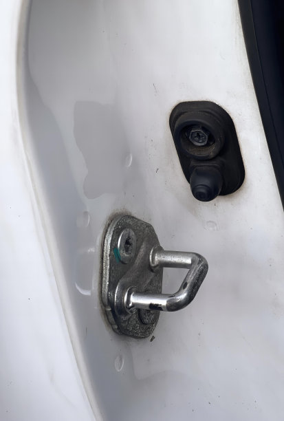 这是一张带有金属门闩和金属把手的厕所的照片，这是一个带有金属门闩的厕所的特写。图片下载