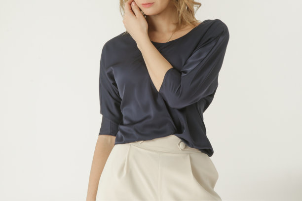 一系列的工作室照片的年轻女模特穿着简单美丽的服装，丝绸缎衬衫和白色阔腿裤图片下载