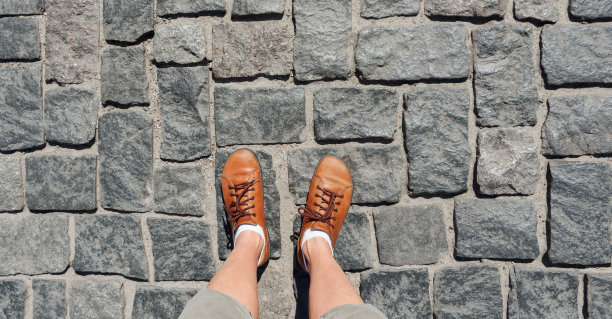 鹅卵石街道旅行男人鞋子自拍脚走人行道石头小路。鹅卵石小径旅行概念旅行脚自拍腿步行街道人行道俯视图。老街人行道俯视图图片下载