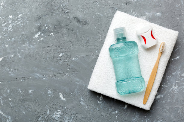漱口水和其他口腔卫生产品在彩色桌面视图与复制空间。平的。口腔卫生。口腔护理产品和空间的文字在浅色背景。概念图片下载