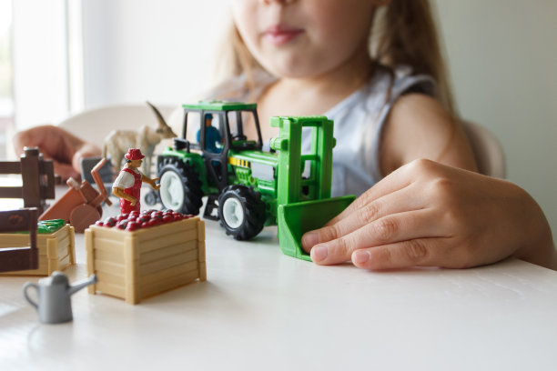 可爱的孩子在玩农具玩具。商业或农业概念图片下载
