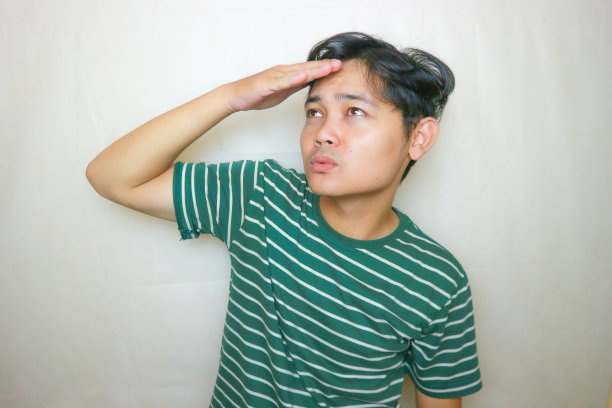 一名印尼亚裔男子身穿绿色衣服，以白色为背景，正在拍摄各种表情的照片图片下载