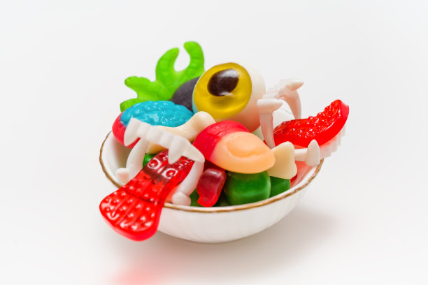 令人毛骨悚然的万圣节糖果碗:手指，眼睛，蜘蛛，大脑，舌头和骨头在白色图片下载