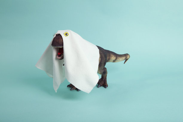 一个塑料霸王龙小雕像，用床单和假眼睛伪装成鬼魂图片下载