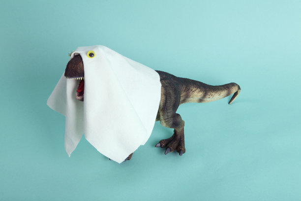 一个塑料霸王龙小雕像，用床单和假眼睛伪装成鬼魂图片下载