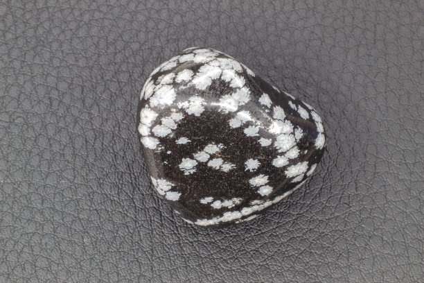 滚落近雪花黑曜石孤立在白色背景图片下载