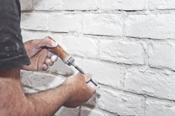 专业建筑商在墙上粘贴装饰瓷砖。工人在墙上安装装饰砖图片下载