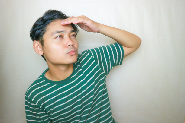 一名印尼亚裔男子身穿绿色衣服，以白色为背景，正在拍摄各种表情的照片图片下载