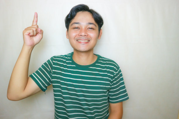 一名印尼亚裔男子身穿绿色衣服，以白色为背景，正在拍摄各种表情的照片图片下载