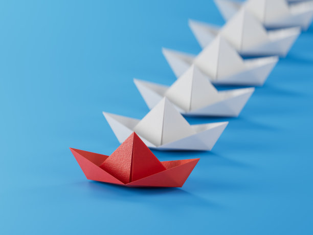 不同的经营理念。新的想法。纸艺风格。有创意的想法。”领导理念用红纸船在白船上。蓝色背景的3D渲染。图片下载