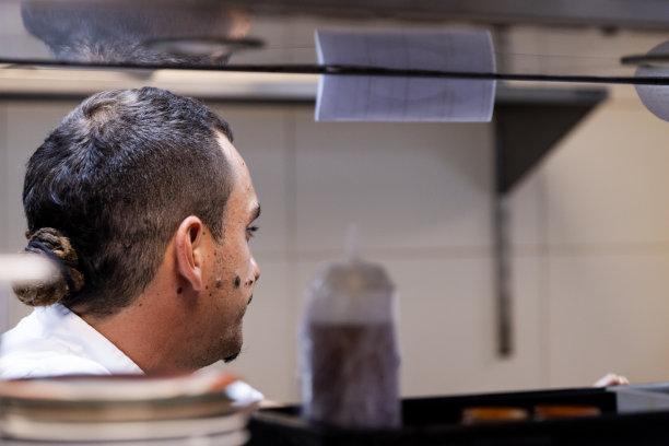 厨师的侧面照片透过餐厅的厨房橱柜图片下载