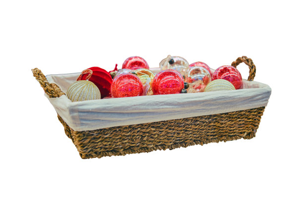 五颜六色的圣诞树球放在商店橱窗的柳条篮子里，孤立在白色的背景上图片下载