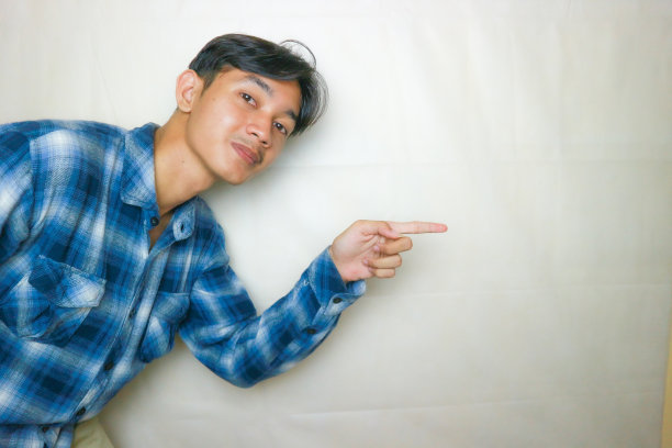 一名印尼亚裔男子身穿蓝色衣服，以白色为背景，正在拍摄各种表情的照片图片下载