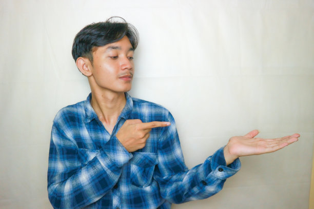 一名印尼亚裔男子身穿蓝色衣服，以白色为背景，正在拍摄各种表情的照片图片下载