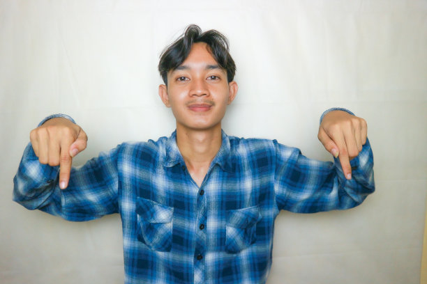 一名印尼亚裔男子身穿蓝色衣服，以白色为背景，正在拍摄各种表情的照片图片下载