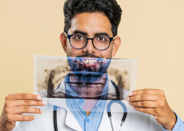 印度一名年轻的正畸医生正在检查一张口腔颌牙的全景x光照片图片下载