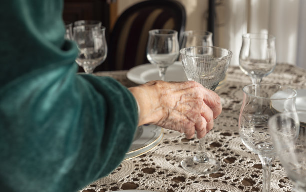 面目全非的老妇人正在准备一顿优雅的圣诞大餐。女性的手在家里为圣诞大餐摆桌子的特写照片。图片下载